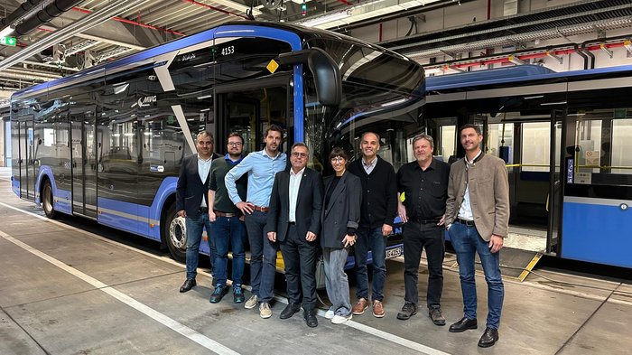 Dreiländertreffen in München Gruppe von acht Personen vor einem blauen MVG-Bus in einer Halle