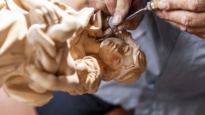 © Alan Bianchi Hand schnitzt detaillierte Holzskulptur einer Mutter mit Kind