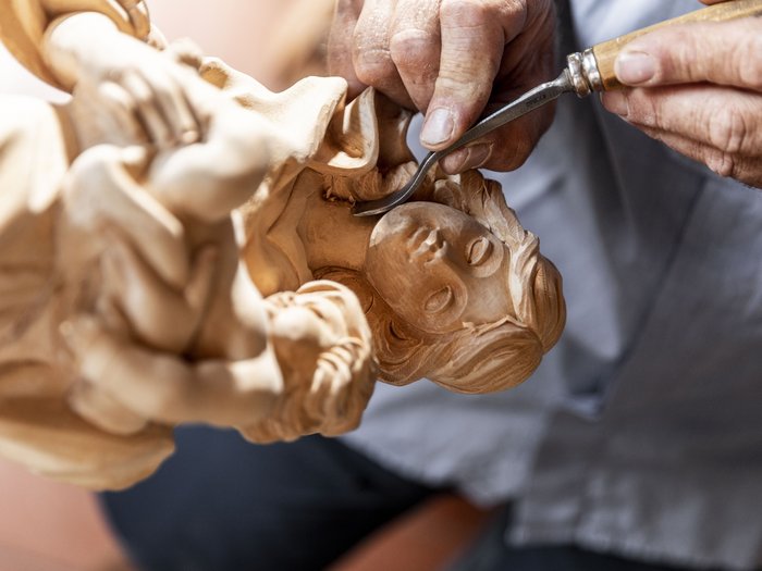 L’artigianato artistico di lvh.apa compie 75 anni Mano intaglia una scultura in legno dettagliata di madre con bambino