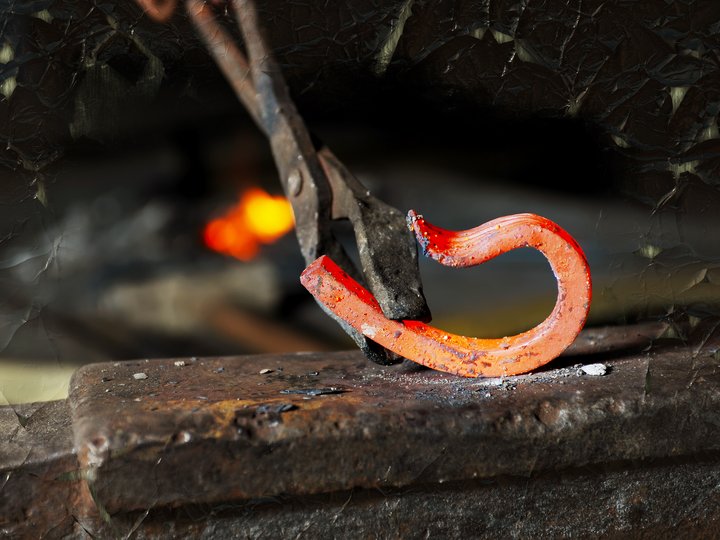 Schmiede und Schlosser Glühendes heißes Metall wird mit Zange beim Schmieden geformt