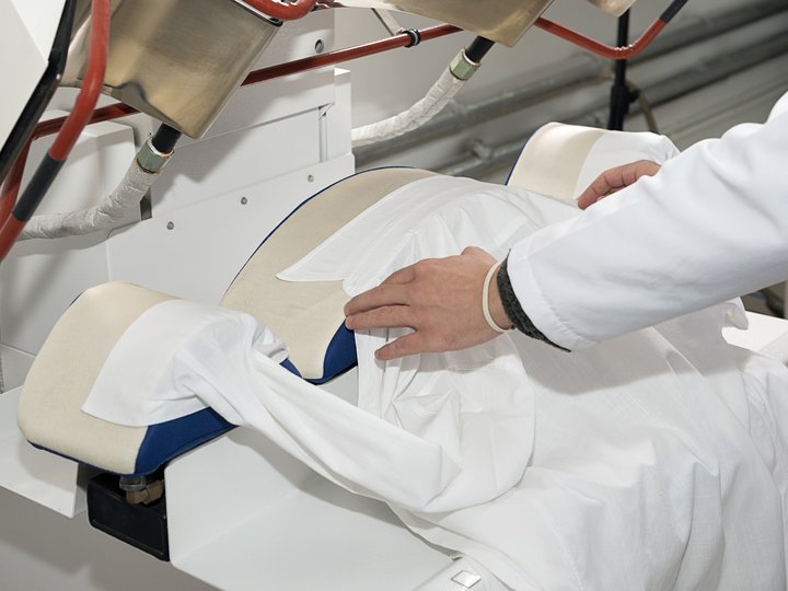 Percorso formativo Persona posa una camicia bianca sulla macchina da stiro industriale