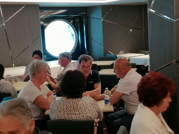 Artigiani anziani in crociera Gruppo di anziani seduti a tavoli in una stanza con finestra rotonda