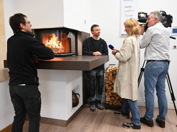 Sicheres Heizen Interview vor einem modernen Kamin mit brennendem Holzfeuer