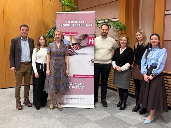 Qualità, individualità e benessere Gruppo di sette persone davanti a un banner promozionale in ufficio