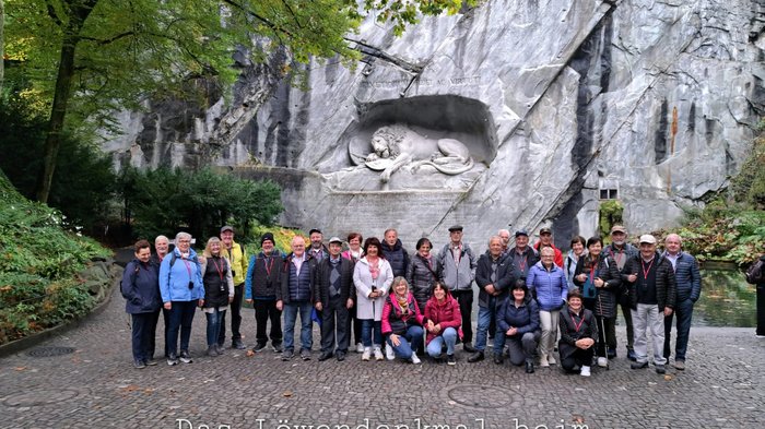 Viaggio autunnale degli artigiani anziani di lvh.apa: puro divertimento e panorama svizzero Gruppo di persone davanti al Monumento del Leone nel Giardino del Ghiacciaio di Lucerna