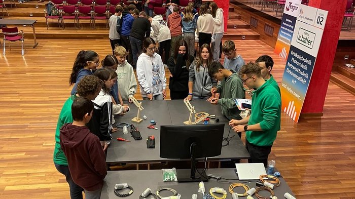 Karriere im Handwerk Schüler und Lehrer bei einem Technik-Workshop mit Kabeln und Holzmodellen