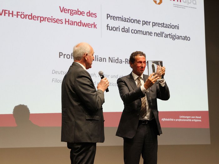 Sostenibilità: l’impronta indelebile dell‘artigianato Consegna del premio VFH per l'artigianato a un uomo sul palco