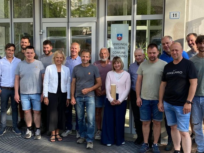 Das Handwerk setzt auf Dialog mit der Gemeinde Gruppenfoto von 16 Personen vor dem Eingang des Gemeindehauses Aldein