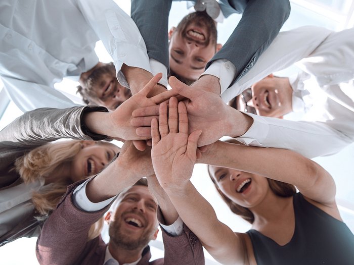 lvh.apa informa sui sistemi sistema di ricompensa tramite premi per la fidelizzazione del personale Team felice in cerchio con le mani unite al centro