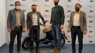 News Vier Männer mit Masken posieren vor lvh apa Hintergrund mit Roller