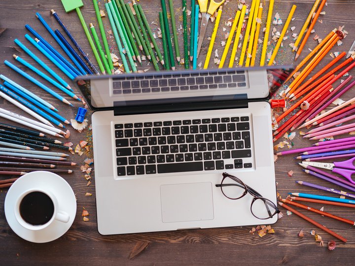 Percorso formativo Portatile su tavolo di legno con matite colorate, caffè e occhiali