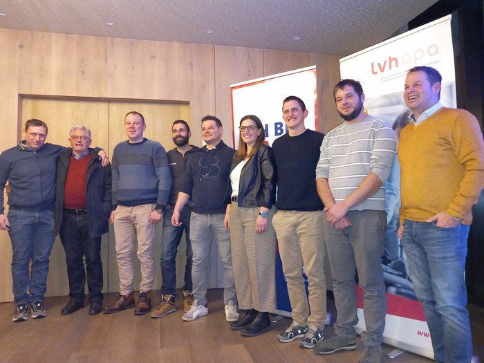 Joachim Pföstl neuer lvh-Ortsobmann Gruppenfoto mit neun lächelnden Personen vor Holzwand und Bannern