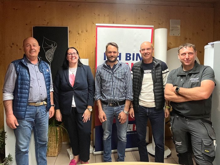 Handwerk in Tscherms setzt auf die Jugend Fünf Personen stehen vor einem Holzpaneel im Innenraum mit Plakat im Hintergrund