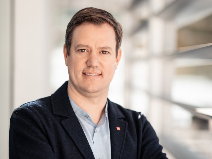 La sicurezza sul posto di lavoro ha la massima priorità Ritratto di uomo con le braccia incrociate in un ufficio moderno