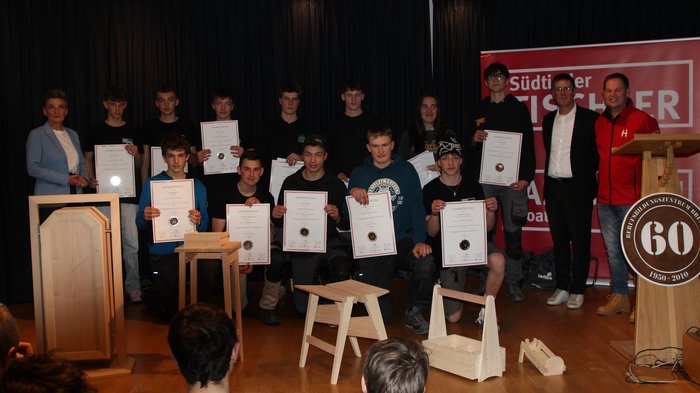Jugendwettbewerb der Tischler/innen 2025: Südtirols Nachwuchstalente zeigen ihr Können Jugendliche mit Urkunden und Holzarbeiten bei einer Auszeichnungsfeier