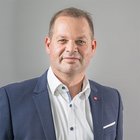 Das Nachhaltigkeitslabel Südtirol Porträt eines Mannes in Anzug vor grauem Hintergrund