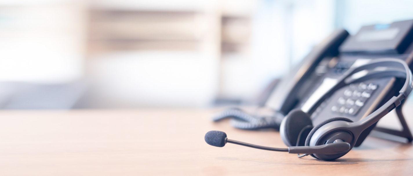 Zwischen Technik und Sternenhimmel Headset vor Telefon auf einem Bürorahmen