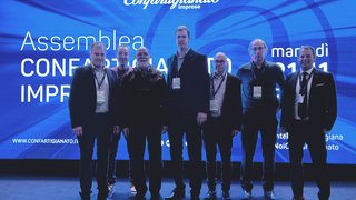 News Sieben Männer stehen vor einer Confartigianato Imprese Veranstaltungswand