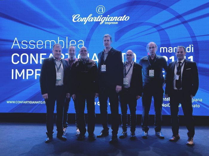 L’artigianato, il motore del made in Italy Sette uomini in piedi davanti a un pannello dell'evento Confartigianato Imprese