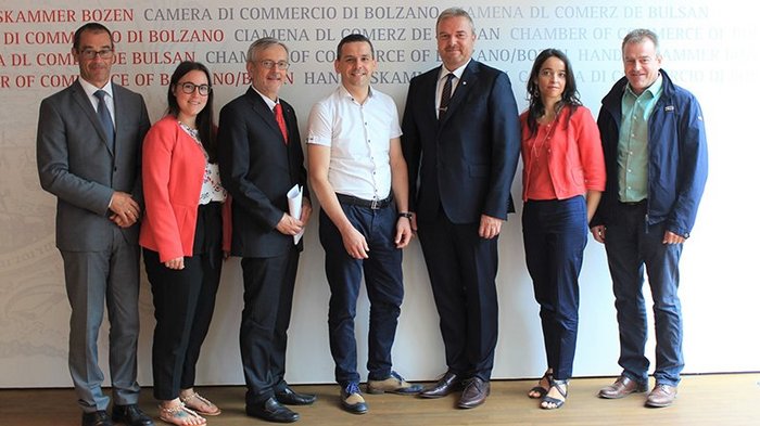 Südtiroler Meisterbund schließt sich der Handelskammer an Sieben Personen posieren stehend vor dem Handelskammer Bozen Hintergrund