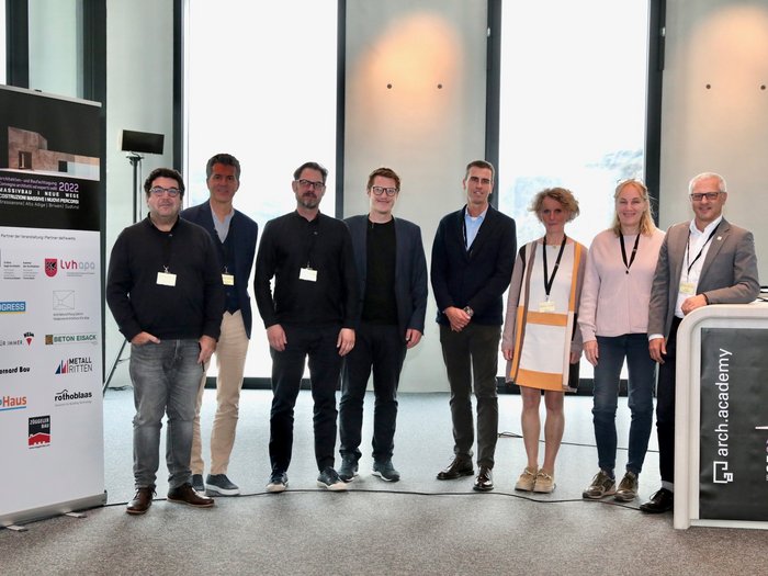 Grande successo per il convegno sulle costruzioni massicce Foto di gruppo di otto persone alla conferenza arch.academy 2022 a Bressanone