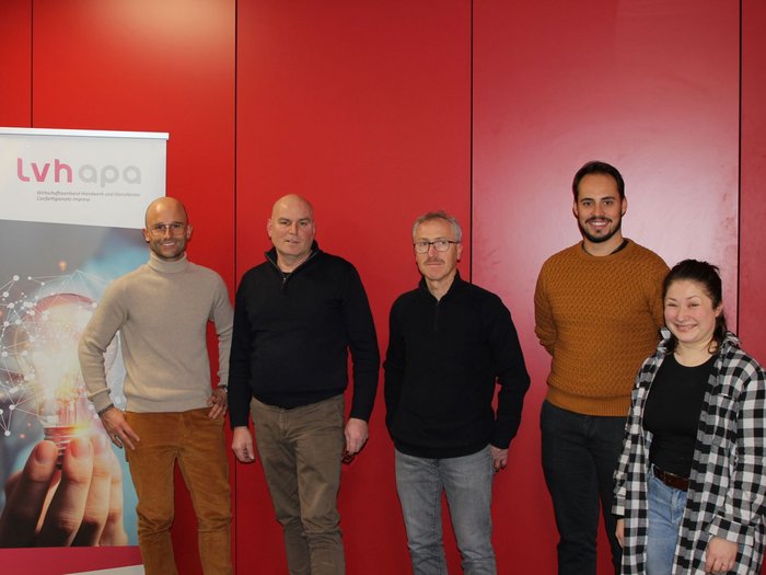 I Calzolai di lvh.apa tra passato, presente e futuro Cinque persone davanti a muro rosso vicino a banner dell'associazione artigiani e servizi