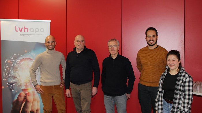 I Calzolai di lvh.apa tra passato, presente e futuro Cinque persone davanti a muro rosso vicino a banner dell'associazione artigiani e servizi