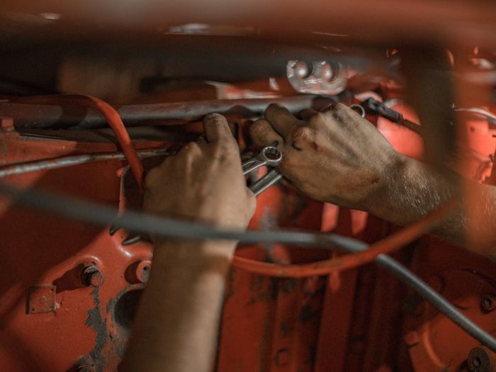 Lehrlingsprämie 300 Mal ausbezahlt Hände reparieren eine Maschine mit Schraubenschlüssel