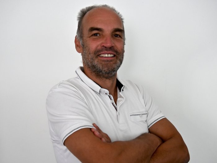 Traffico lungo l'asse del Brennero Uomo sorridente con barba e polo bianca davanti a muro bianco