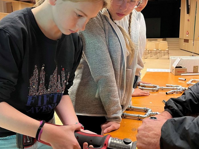 SkillsDay a Vipiteno: Mettersi all’opera Ragazzi osservano utensili e raccordi metallici su un tavolo