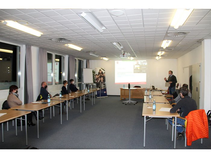 Un sostegno di valore durante la pandemia Persone con mascherine durante una presentazione in una sala conferenze luminosa