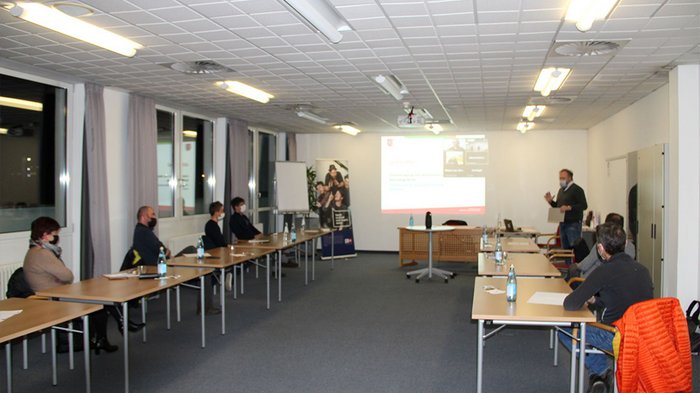 Un sostegno di valore durante la pandemia Persone con mascherine durante una presentazione in una sala conferenze luminosa