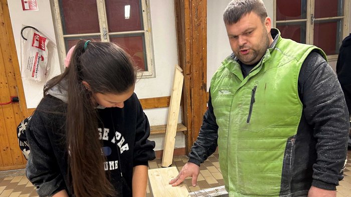 JHW-Wipptal Frau und Mann arbeiten gemeinsam an Holzprojekt in Innenraum