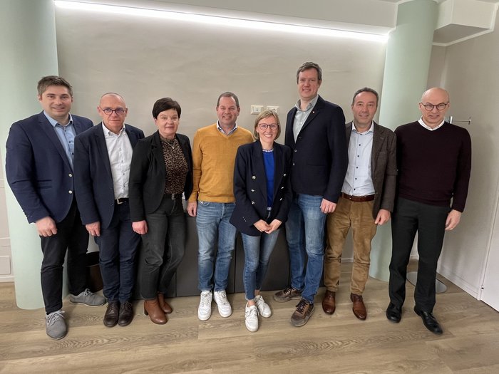 I vertici di lvh.apa incontrano l'assessora provinciale Magdalena Amhof: un dialogo orientato al futuro Foto di gruppo di otto persone davanti a una parete chiara