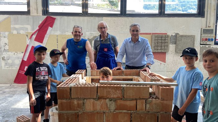 Kids-Academy 2024: Eine lehrreiche Erfahrung im Vinschgau Kinder und Erwachsene beim gemeinsamen Mauerbau in einer Werkstatt