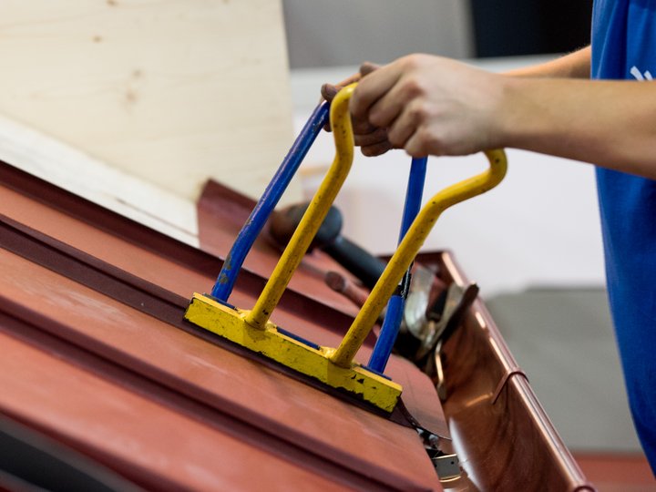 Lattonieri edili e artistici Persona fissa lastra di metallo sul tetto con attrezzo