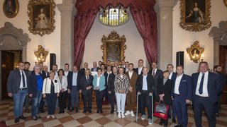 News Gruppenfoto von Menschen in einem prunkvollen Raum mit Gemälden und rotem Vorhang