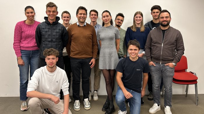 Una ventata di aria fresca per l'artigianato: Via ai Giovani Artigiani della Bassa Pusteria/Val Badia Gruppo di dodici giovani adulti sorridenti davanti a parete bianca