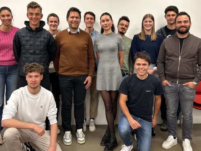 Frischer Wind im Handwerk: Die Junghandwerker/innen im Unterpustertal/Gadertal starten durch Gruppe von zwölf lächelnden jungen Erwachsenen vor weißer Wand