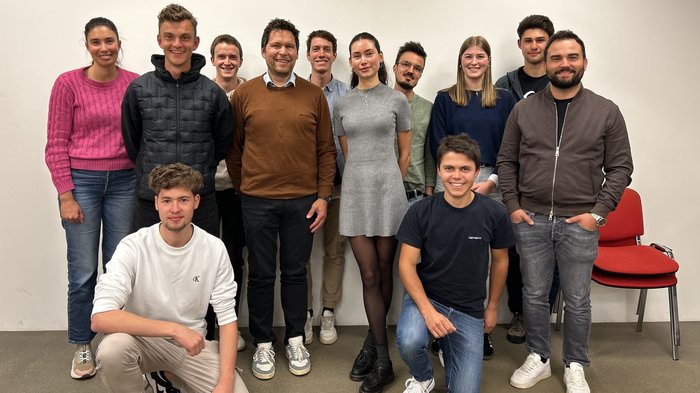 Frischer Wind im Handwerk: Die Junghandwerker/innen im Unterpustertal/Gadertal starten durch Gruppe von zwölf lächelnden jungen Erwachsenen vor weißer Wand