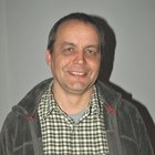 Costruttori in legno e carpentieri Uomo di mezza età con camicia a quadri e giacca grigia che sorride davanti a parete bianca