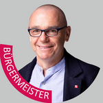 Bozen Land Porträt eines lächelnden Mannes mit Brille und Sakko, Bürgermeister-Banner