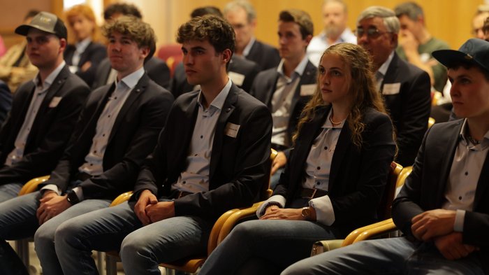 Aperitivo WorldSkills alla Casa dell'Artigianato Giovani adulti in jeans e blazer seduti attentamente durante un evento