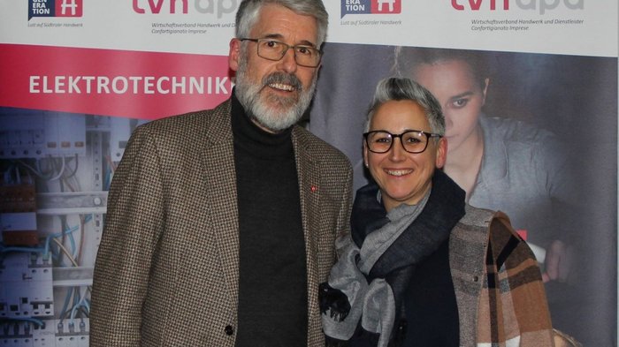 Neue Chance Photovoltaik Zwei Personen vor einem Werbebanner für Elektrotechnik und Handwerksverband