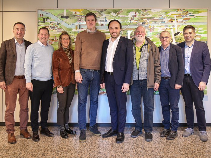 Definire il percorso educativo per il futuro Otto persone in piedi davanti a una mappa agricola appesa alla parete