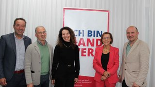 News Fünf lächelnde Personen vor einem Banner mit Text Ich bin Landwirt