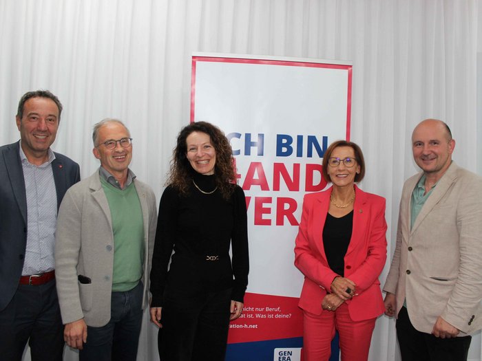 Die Jahresversammlung der Berufsgemeinschaft der Mediendesigner/innen im lvh fand kürzlich im Hauptsitz der Firma Salewa in Bozen statt. Dabei wurde die Obfrau mit der bronzenen Ehrennadel geehrt. Fünf lächelnde Personen vor einem Banner mit Text Ich bin Landwirt