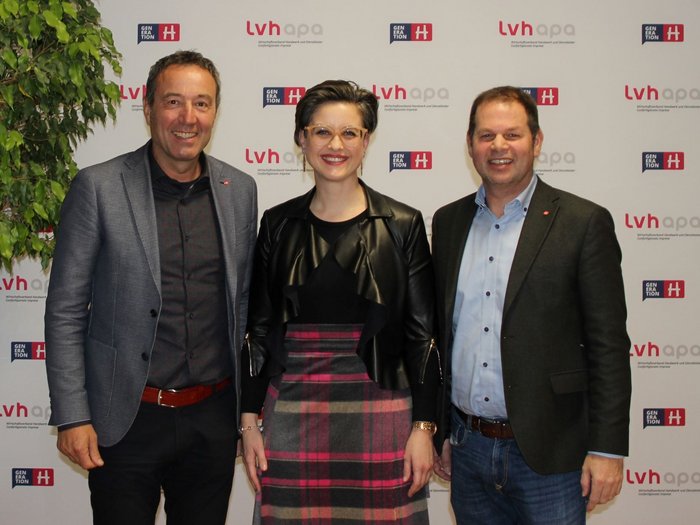 Schönheitspfleger/innen mit neuer Obfrau Drei lächelnde Personen vor lvh a p o Hintergrund stehen zusammen