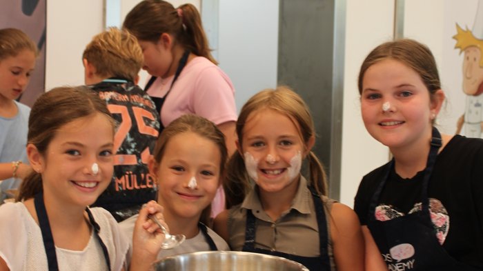 Backspaß und Kreativität – KidsAcademy backt in Kaltern Fröhliche Kinder backen gemeinsam mit Mehl im Gesicht und Küchenutensilien