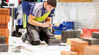 News Handwerker misst Ziegelsteine während Bauarbeit und Planung